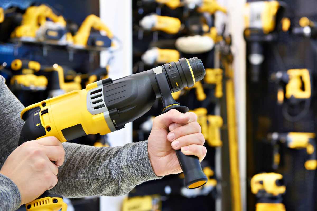 Hammer drill in hands at shop