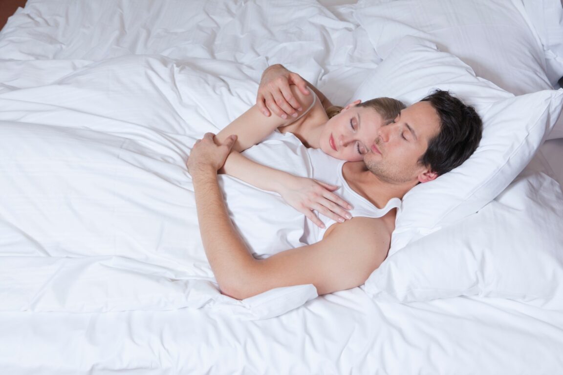 couple in bed, embraced, asleep